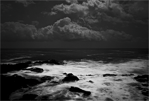 Night Photography Example. Black-and-white photograph of Pacific Ocean in Kailua Kona, Hawaii, at night under full moon.